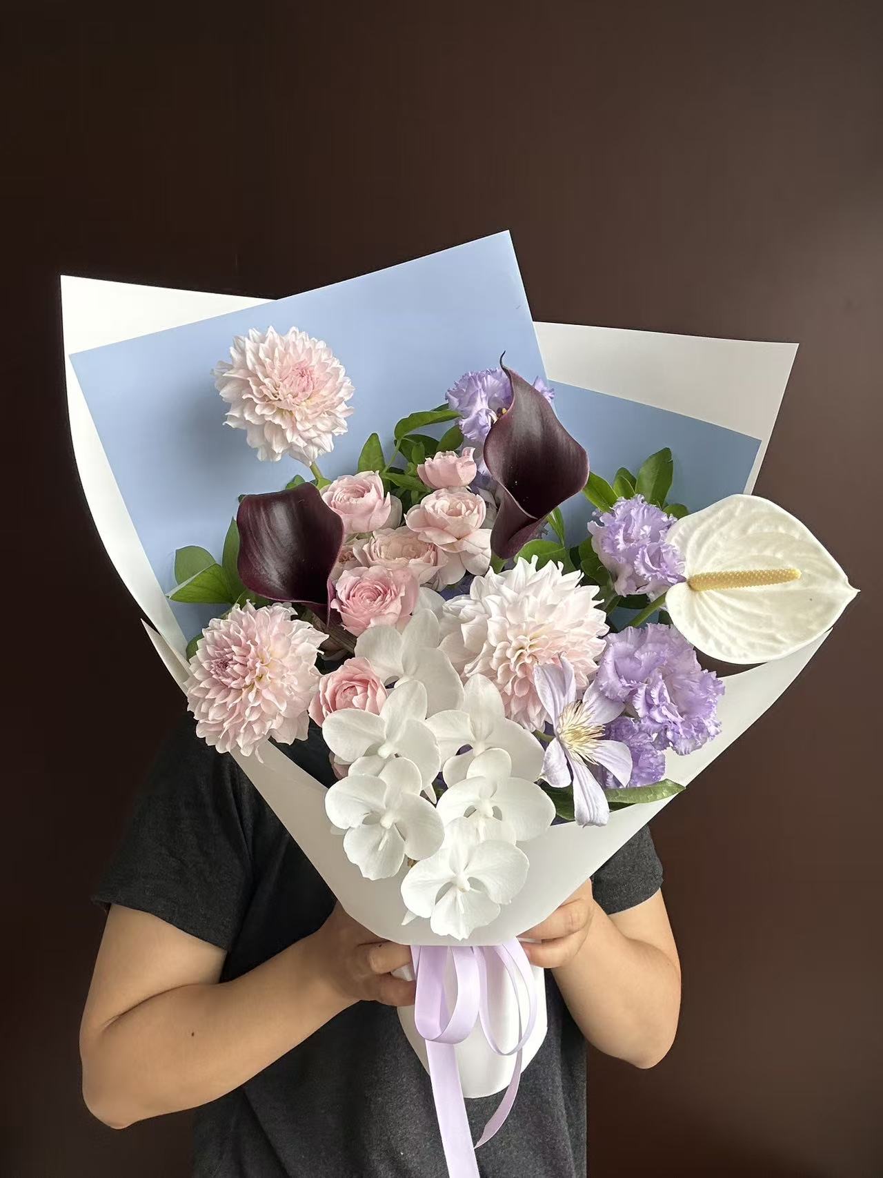 杭州蓝粉紫马蹄莲花束实拍，浅蓝包装、粉色玫瑰、白色兰花、紫色花材和深色马蹄莲组合