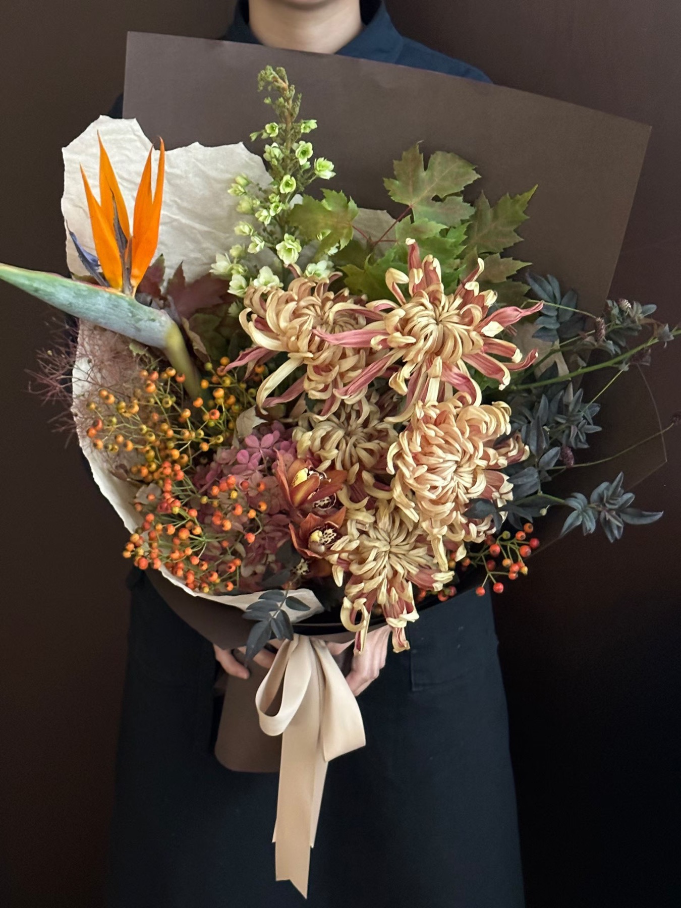 杭州教师节秋色成熟花束真实作品，菊类花材、天堂鸟、果材和深色包装组合，适合恩师和退休老师参考